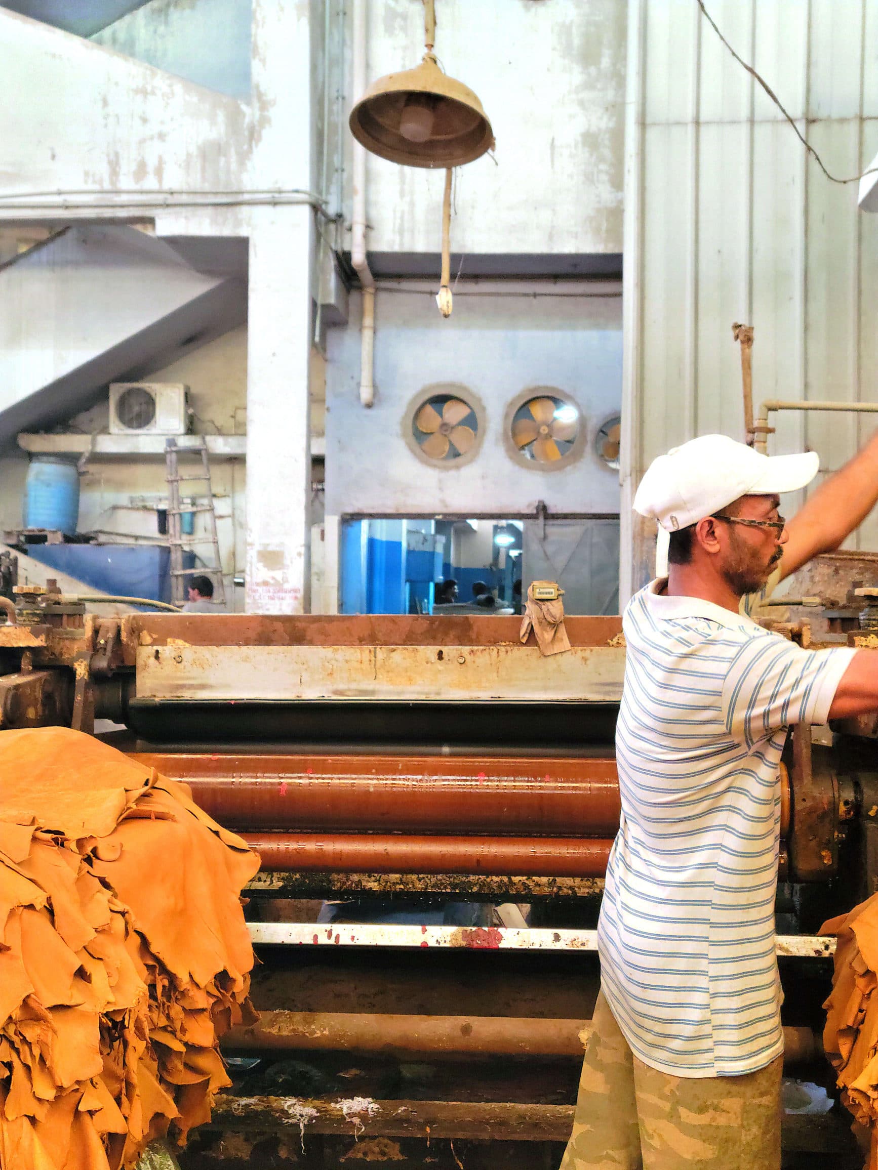 A worker feeding hides through a roller at the Xara tannery